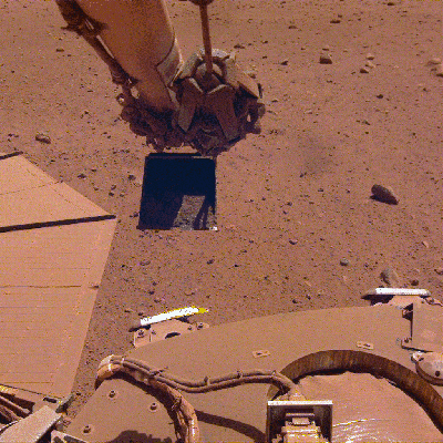 El módulo InSight hace un GIf muestra el módulo InSight vertiendo arena junto a sus paneles solares: una "gancho" diseñado para limpiarlos.