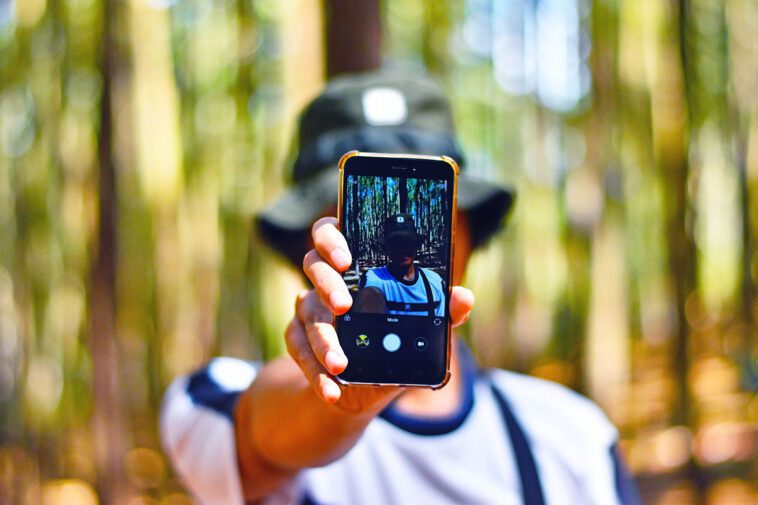 Fan de tech ? Les solutions pour limiter votre empreinte écologique 1 Homme Smartphone Nature Foret