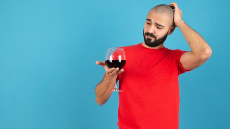 Aimez-vous le vin rouge ? Les scientifiques expliquent pourquoi il peut causer des maux de tête 1 Jovem com copo de vinho tinto
