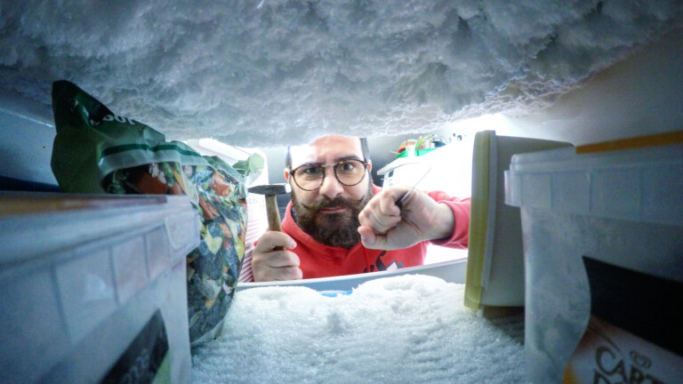 Ton réfrigérateur fait du bruit - voici les raisons 6 Homme retirant de la glace du congélateur