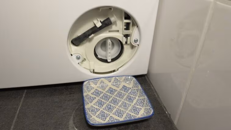 Nettoyer le filtre à peluches : Votre machine à laver avale-t-elle aussi des pièces de monnaie ? 1 Waschmaschine mit Schale vor Flusensieb