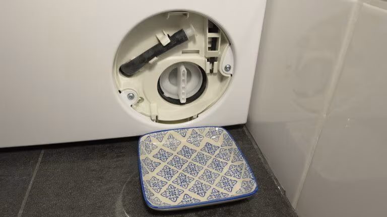 Nettoyer le filtre à peluches : Votre machine à laver avale-t-elle aussi des pièces de monnaie ? 2 Waschmaschine mit Schale vor Flusensieb