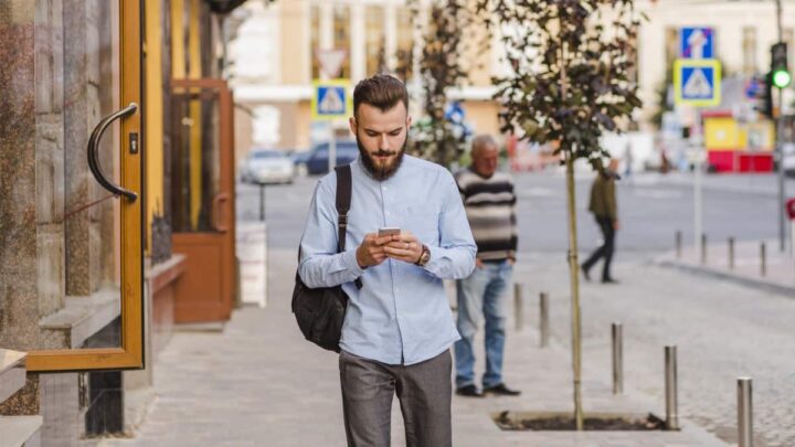 Quelles applications sont les plus sûres : celles sur Android ou iOS ? L'enquêteur répond 2 Jeune homme sur smartphone dans la rue