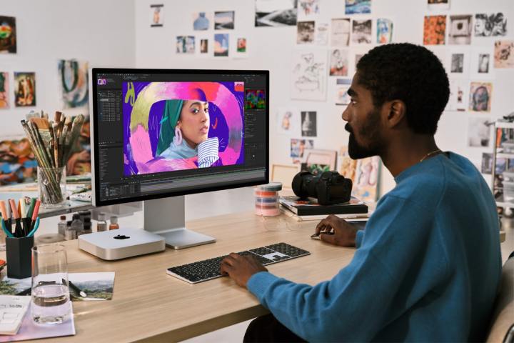 Même un Mac mini relooké ne parviendra pas à me séduire 3 Une personne utilisant un Mac Mini assise à un bureau.