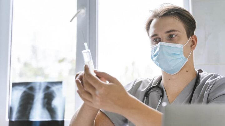 Des spécialistes expliquent ce qu'il ne faut jamais faire avant de se faire vacciner 3 Professionnel de santé avec un vaccin dans la main et un rayon X de poumon