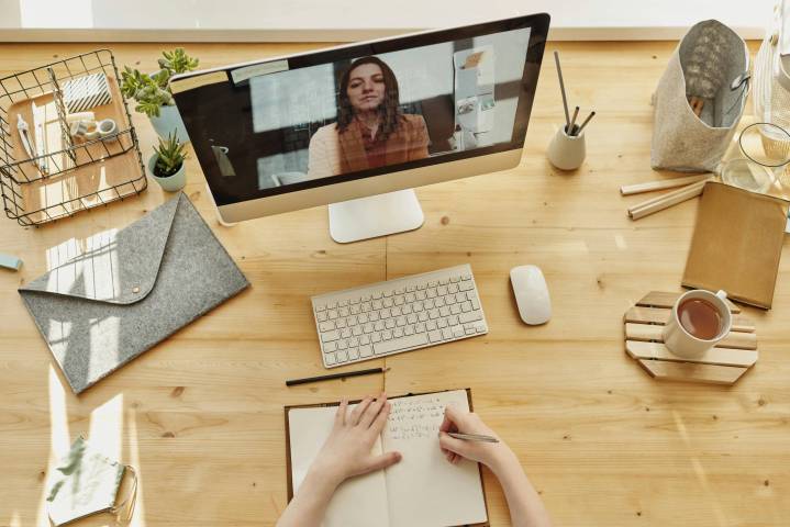 Zoom débute un nouvel assistant IA personnalisable 2.0 2 vue de dessus d'une personne participant à une réunion Zoom à son bureau