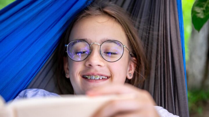 Interdire les téléphones à l'école n'améliore ni les résultats scolaires ni la santé mentale, révèle une étude 3 Enfant avec lunettes utilisant un smartphone