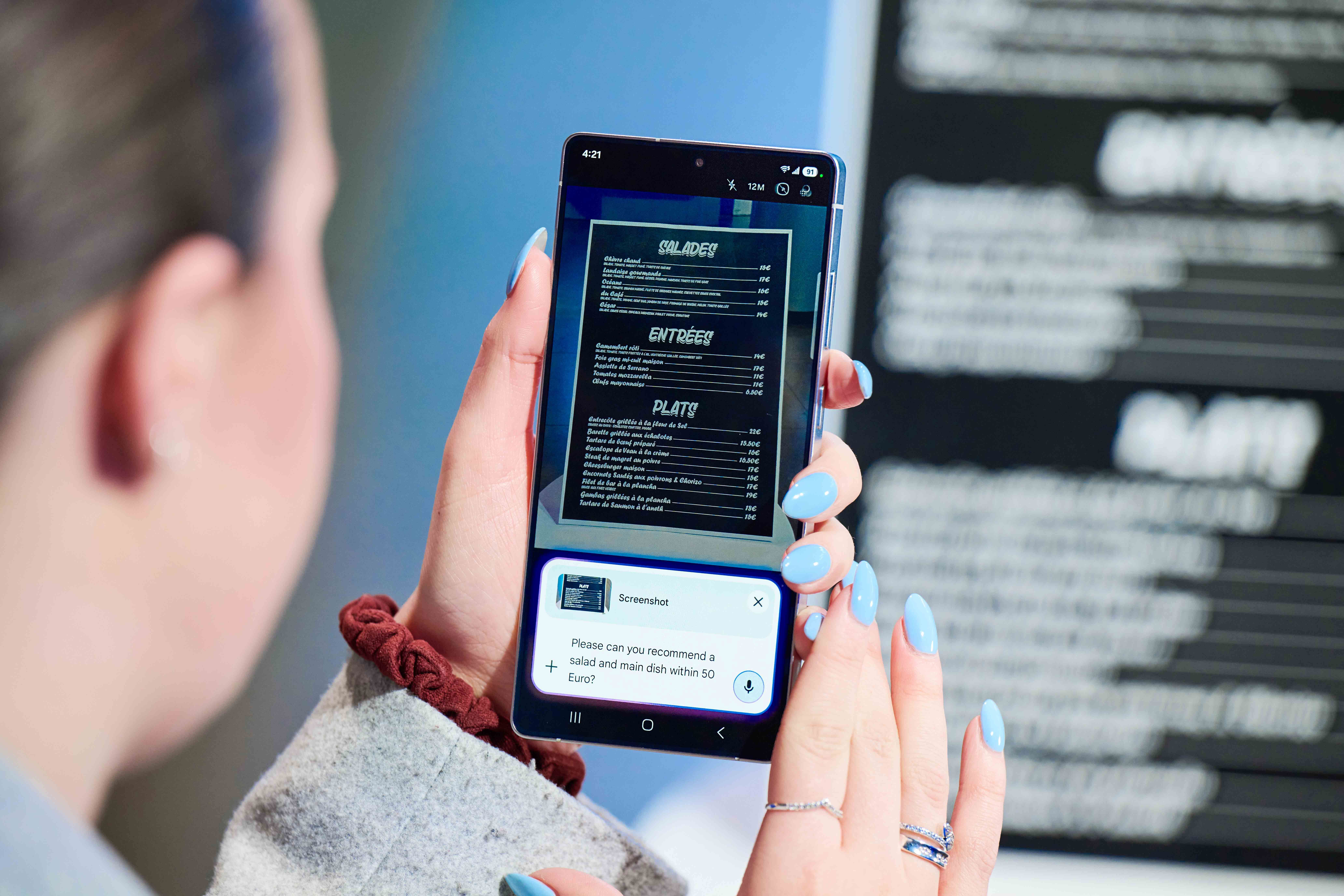 Le Samsung Galaxy S25 Ultra est enfin là : bienvenue dans l'ère des 'IA-phones' 3 Une femme traduisant un menu de restaurant avec les nouvelles fonctionnalités d'IA et Gemini sur son Galaxy S25 Ultra