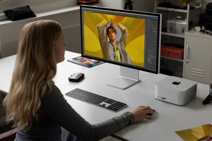 Une personne utilise un Apple Mac Studio et un moniteur Studio Display à un bureau.