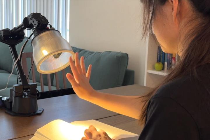 Un chercheur avec le prototype de lampe robotique style Pixar d'Apple.