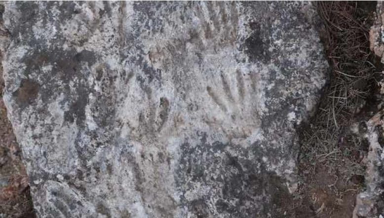 Cette croix gravée sur une roche pourrait être l'œuvre d'art la plus ancienne jamais découverte : une datation incroyable 3 Les empreintes de pieds et de mains. Crédit: D.D. Zhang et al. / Science Bulletin