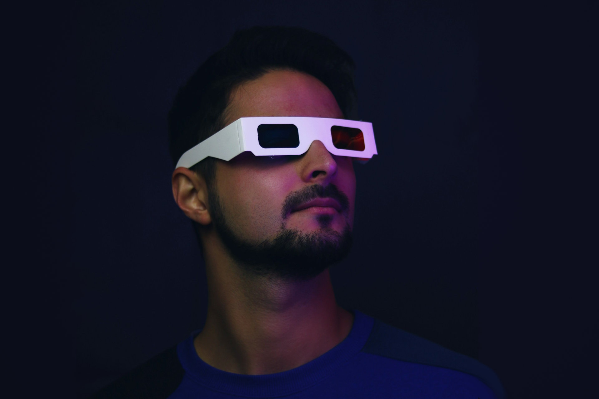 J'ai été époustouflé par ces lunettes intelligentes qui transforment n'importe quelle vidéo en expérience 3D 2 Une personne dans un environnement sombre porte des lunettes 3D anaglyphiques.