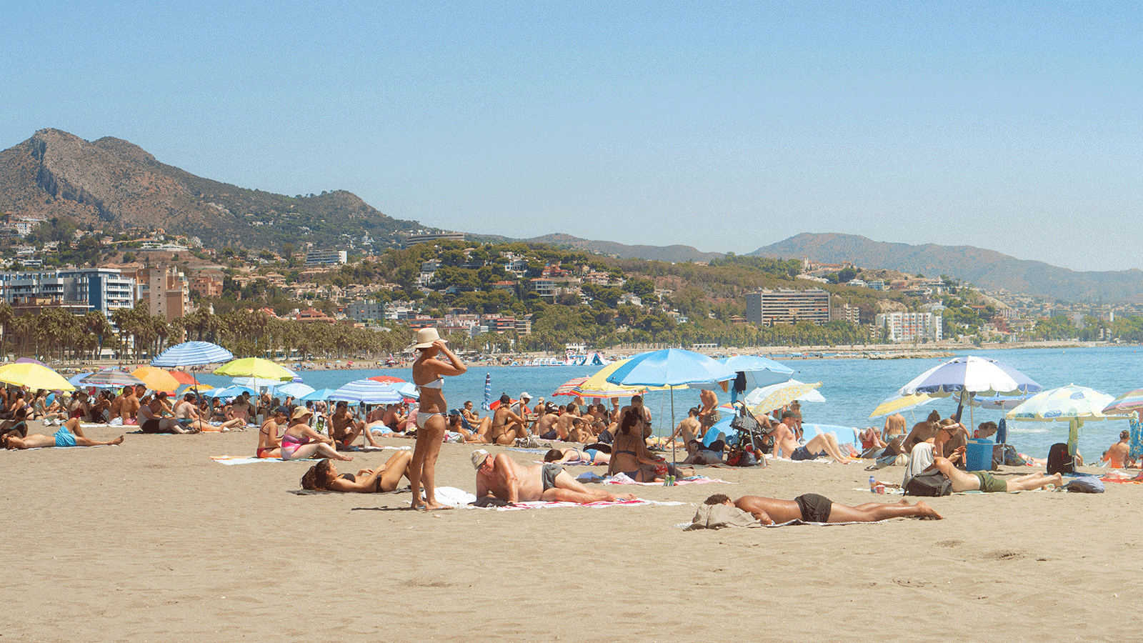 La destination la plus prisée de Booking n'a pas de plage mais compte plus de 100 parcs 3 gente tomando el sol en la playa de Málaga