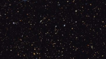 Les galaxies les plus distantes jamais photographiées par le JWST apparaissent comme de petites taches rougeâtres dans l'image qui combine les données des caméras MIRI et NIRCam du JWST. Crédits : NASA/ESA/CSA/STScI