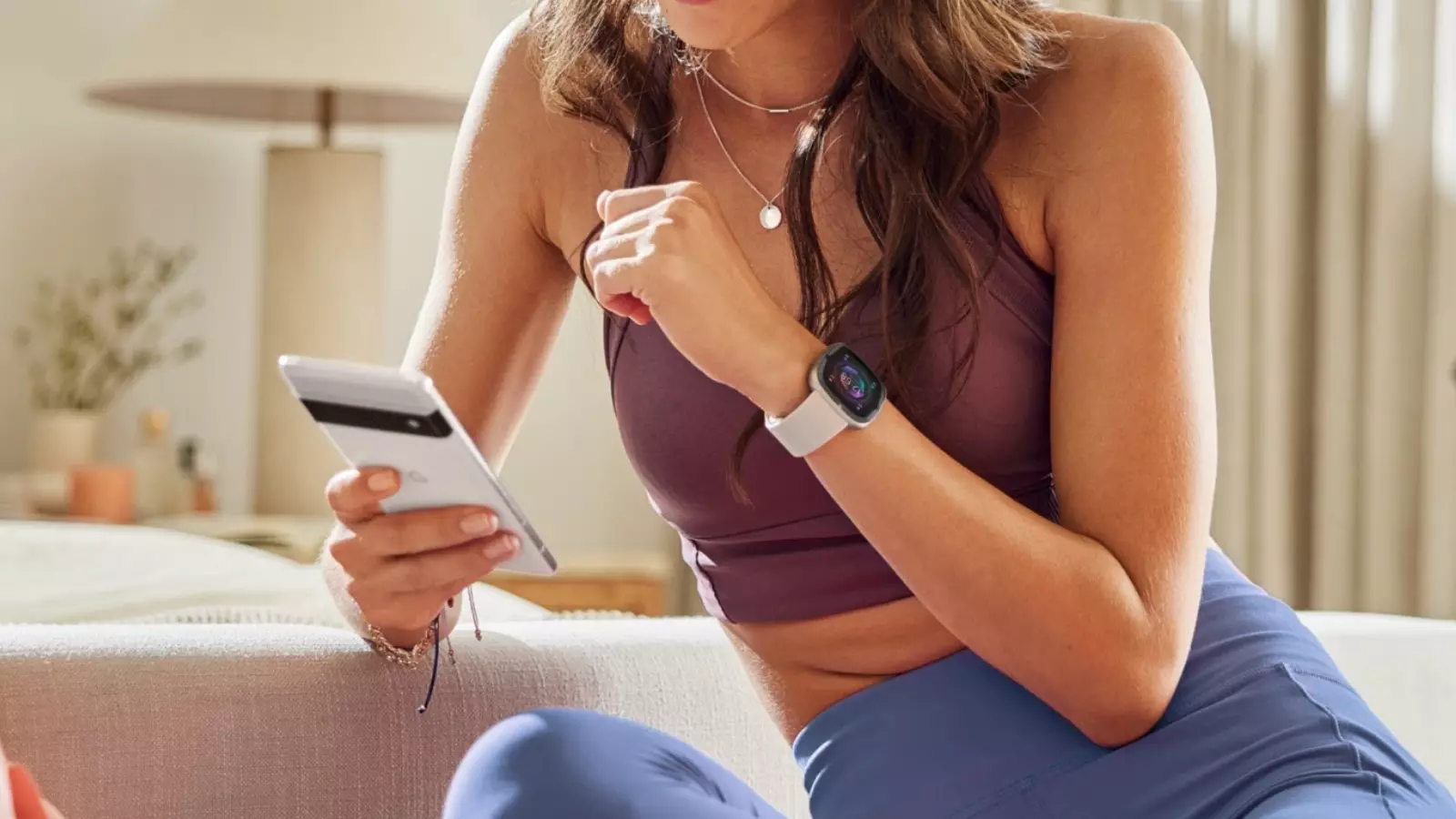 3 montres avec Alexa intégrée pour contrôler votre maison depuis le poignet 4 Chica con el reloj Fitbit Sense 2 y un Google Pixel en la mano