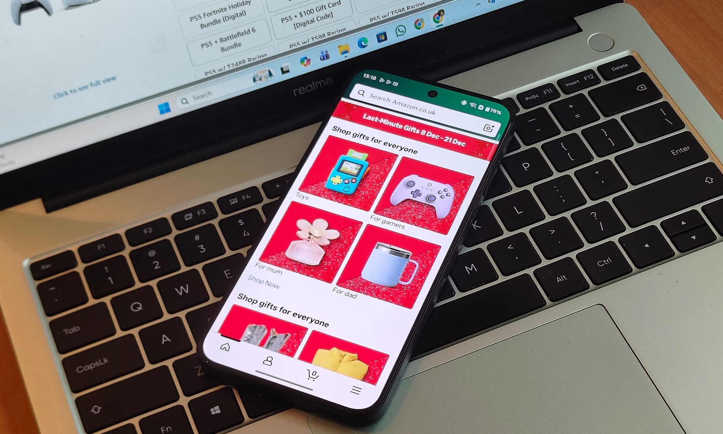 Maîtrisez vos achats d'après Noël grâce à ces conseils incontournables 2 Un téléphone Android affichant l'écran d'accueil de l'application Amazon, sur un clavier d'ordinateur portable.