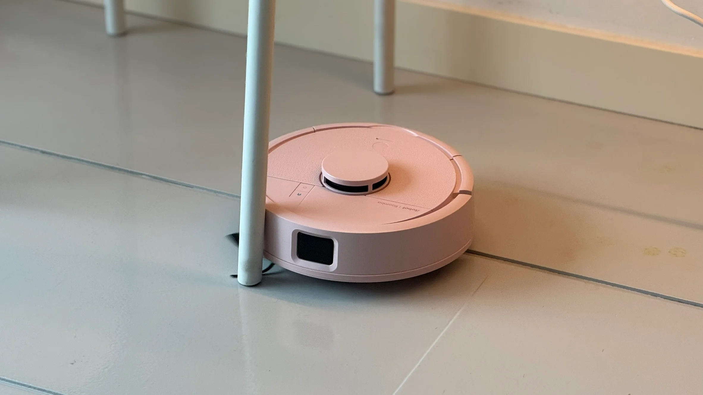 iRobot présente le Roomba Mini, le robot nettoyeur au style épuré et compact 5 Le dispositif nettoyant près d'une patte de table