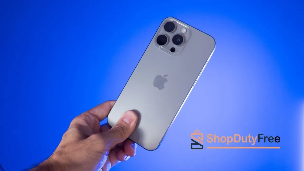 Quel est le truc des iPhone de ShopDutyFree pour coûter 200 euros de moins : sont-ils neufs ou reconditionnés ? 2 iPhone 15 Pro Max en main avec logo de ShopDutyFree
