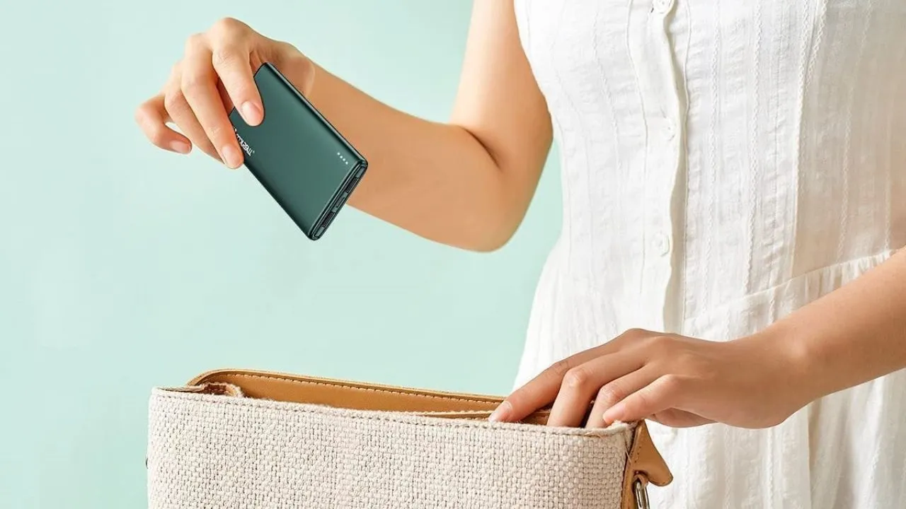 Ils m'ont confisqué ma batterie portable à l'aéroport pour non-respect des règles Évitez que cela ne vous arrive 4 Femme rangeant une batterie externe dans son sac