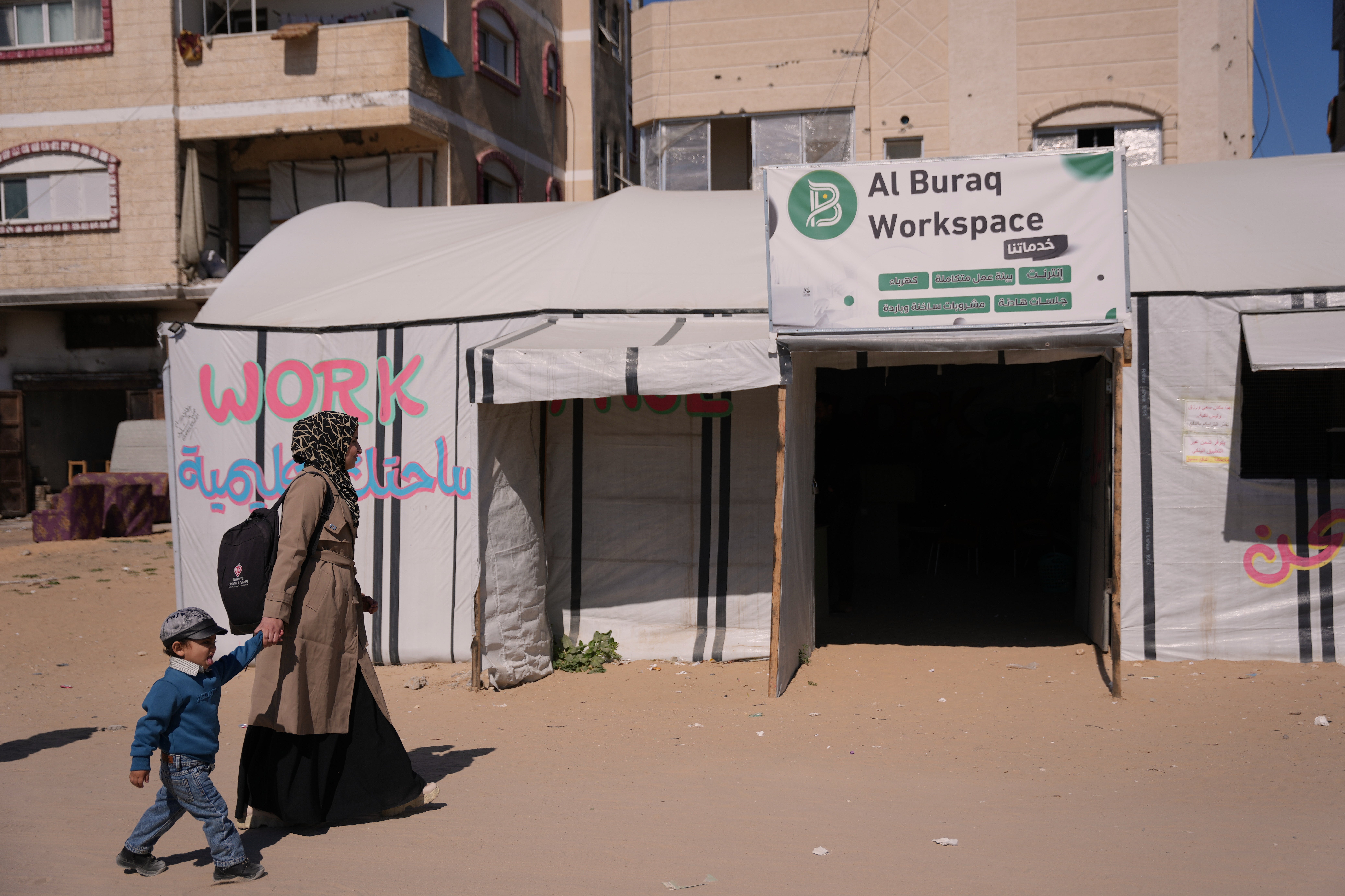 Les travailleurs numériques de Gaza freelancent pendant les coupures d'électricité 3 La graphiste palestinienne Reem Alkhateeb, 33 ans, et son fils Ahmed arrivent à une tente transformée en espace de coworking à Khan Younis, sud de la bande de Gaza, le 9 mars 2026. (Photo AP/Abdel Kareem Hana)