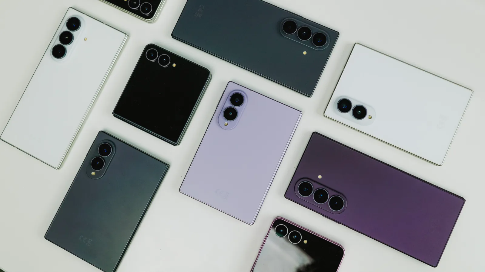 49 smartphones et tablettes Samsung qui seront mis à jour vers One UI 9 très prochainement 3 Vue zénithale de plusieurs terminaux pliables Samsung Galaxy Z Fold8 et Flip8 dans des couleurs lavande, blanc et gris foncé.