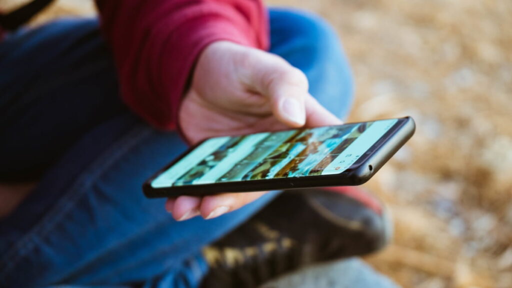 Votre téléphone ne reçoit plus de mises à jour : est-il vraiment sûr de continuer à l’utiliser 3 Personne tenant un smartphone avec la galerie ouverte
