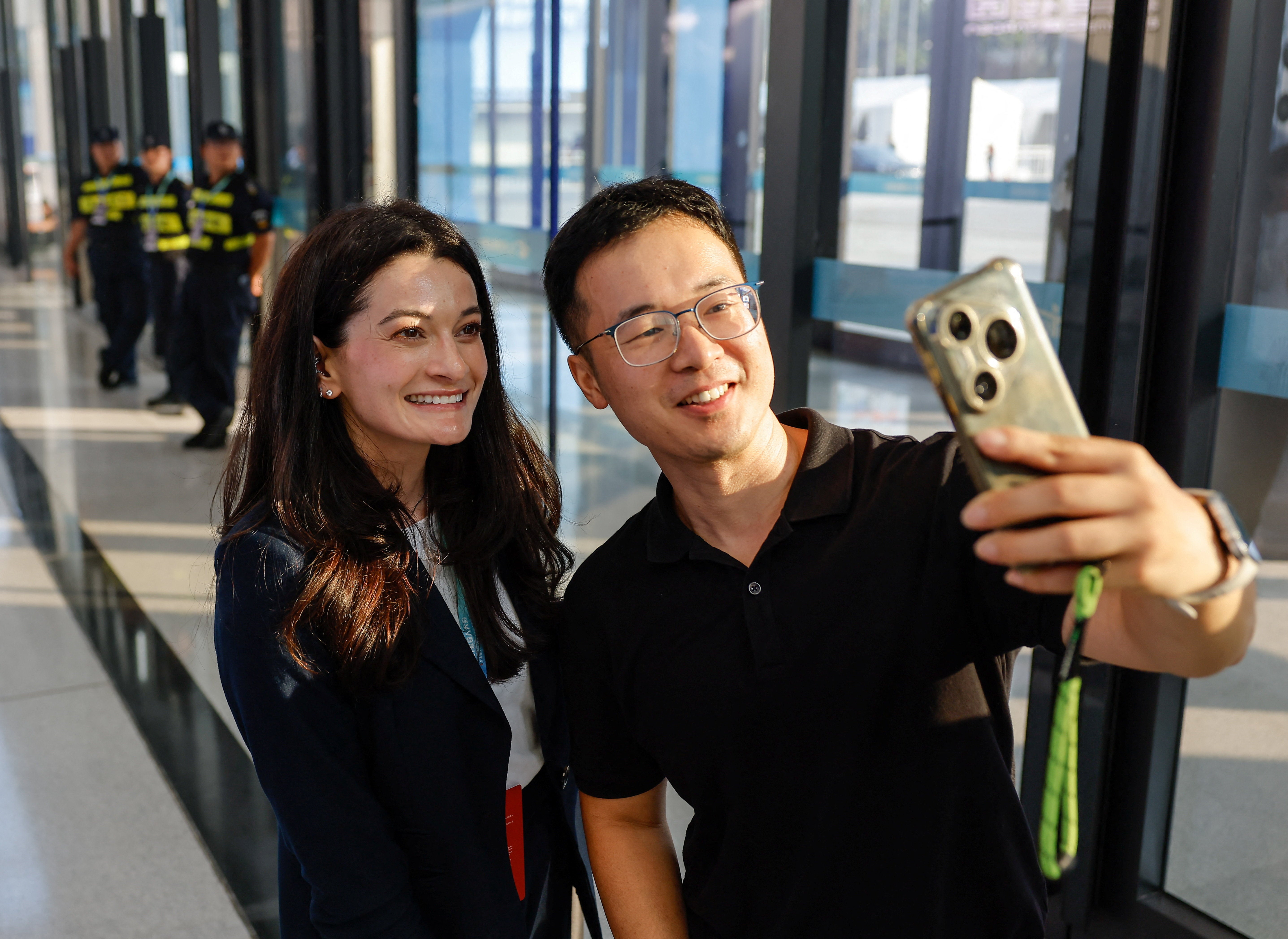 Madison Huang, directrice principale du marketing produit chez NVIDIA et fille de Jensen Huang, prend un selfie avec un visiteur au World Robot Conference 2026, à Pékin.