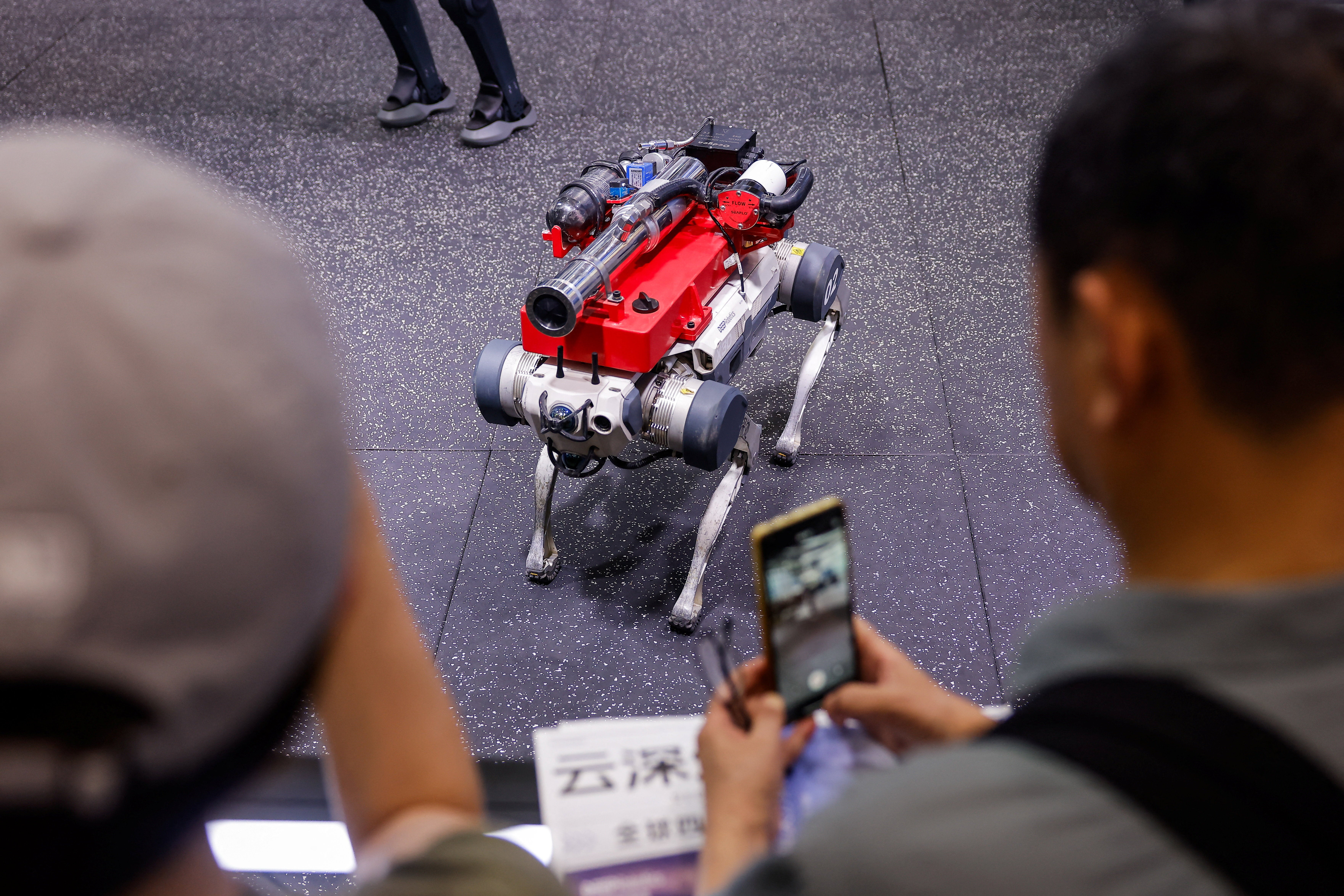 Des personnes photographient un chien robot Deep Robotics X30 sur le stand de la société au World Robot Conference 2026.