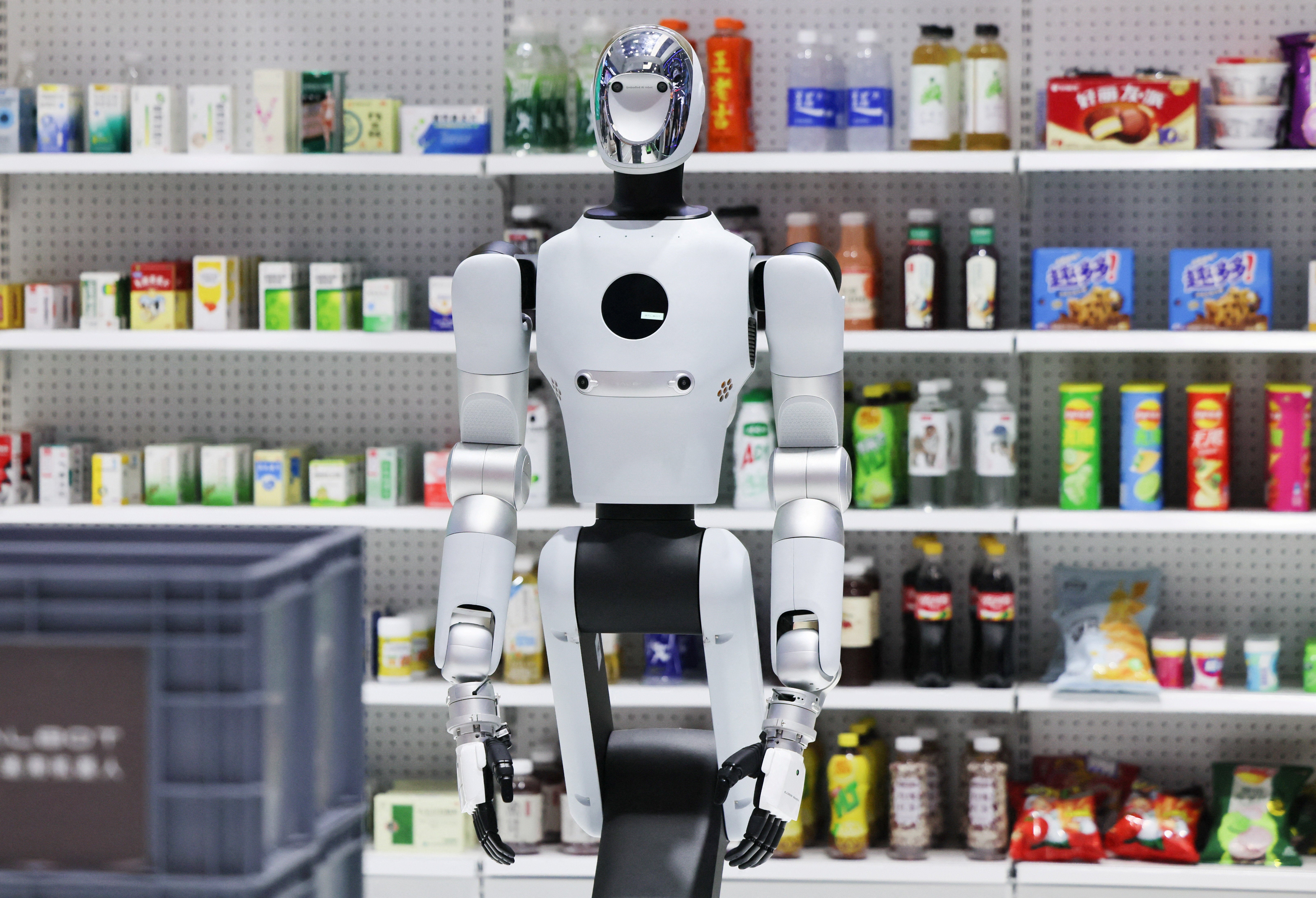 Un robot Galbot G1 exposé à côté d’étagères avec des marchandises sur le stand de la société au World Robot Conference 2026.