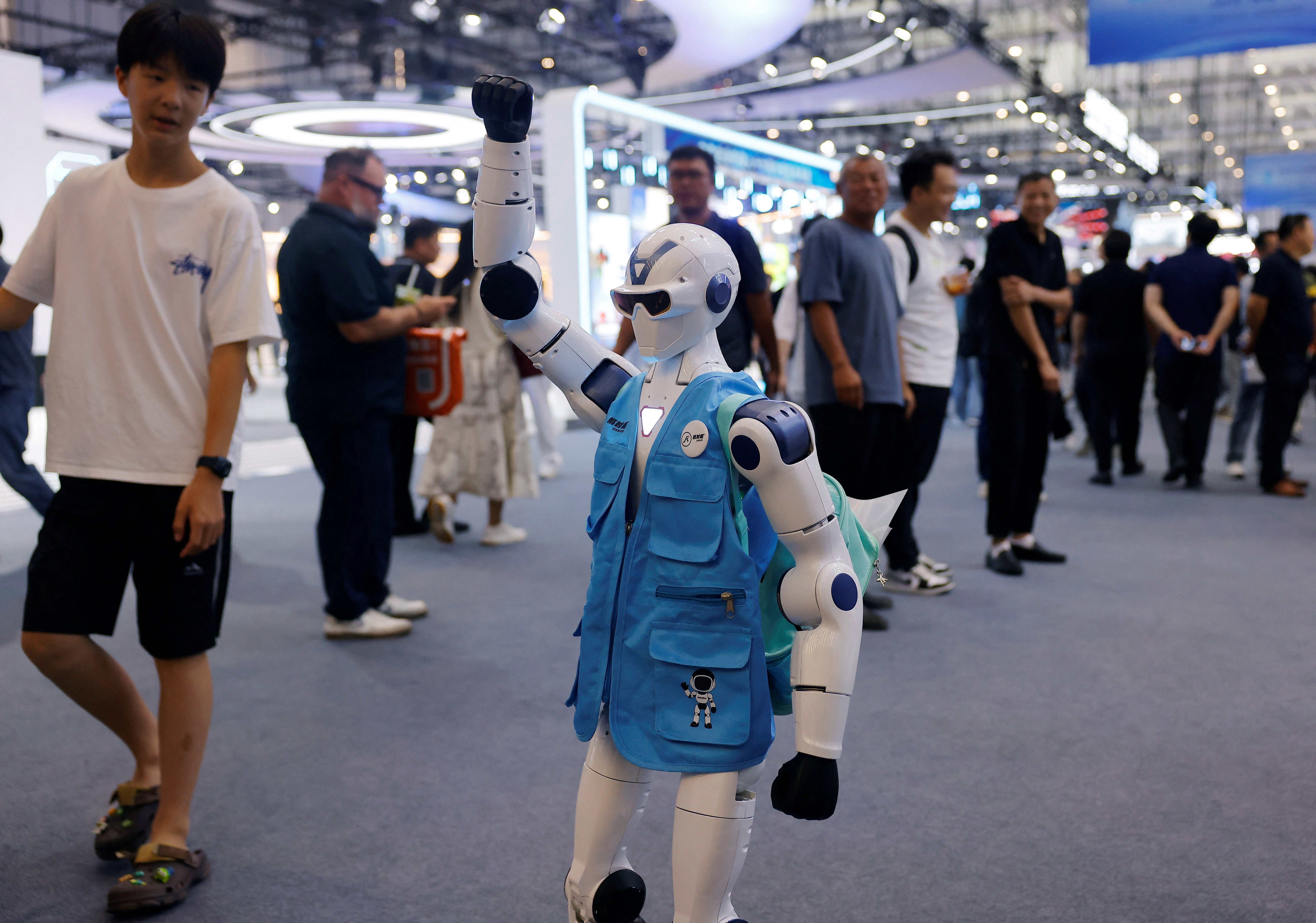 Des personnes regardent un robot Unitree R1 portant un gilet marqué au World Robot Conference 2026.