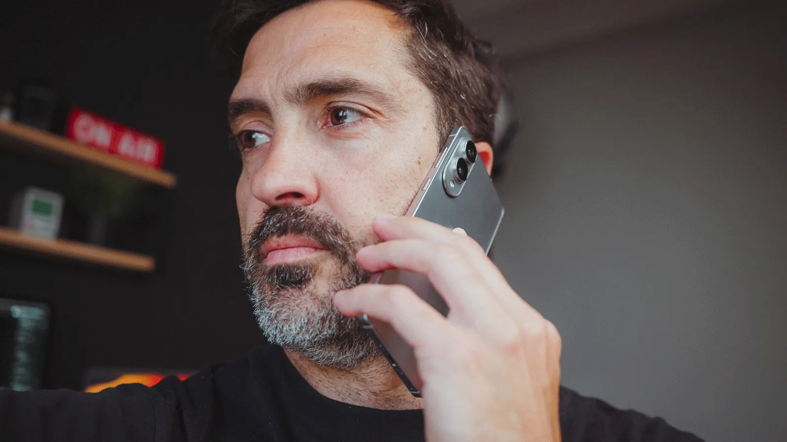 Comment identifier un appel téléphonique inconnu : toutes les astuces efficaces 3 Premier plan d'un homme parlant au téléphone avec un Samsung Galaxy S25 Edge, tenant l'appareil contre son oreille.