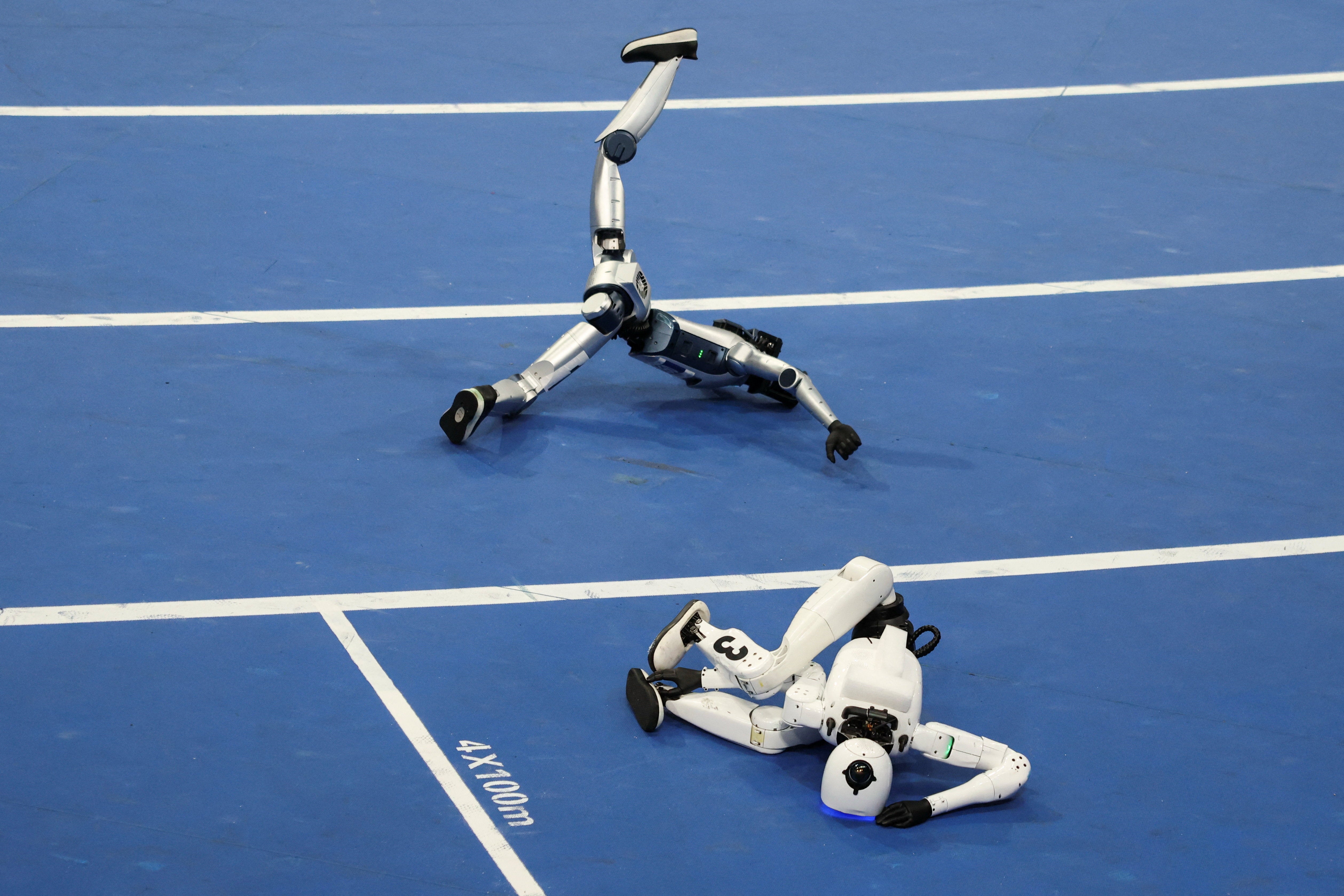 Un robot humanoïde Tiangong Omni et un robot humanoïde Honor tombent après la finale du 100 mètres du groupe petite taille