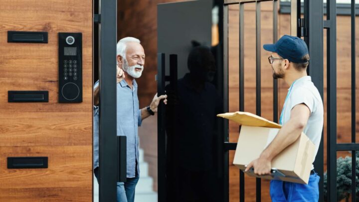 4 800 € pour une sonnette connectée à 140 € : l’arnaque qui a escroqué des dizaines de seniors 3 Une personne âgée ouvre la porte à un livreur, tenant des colis à la main