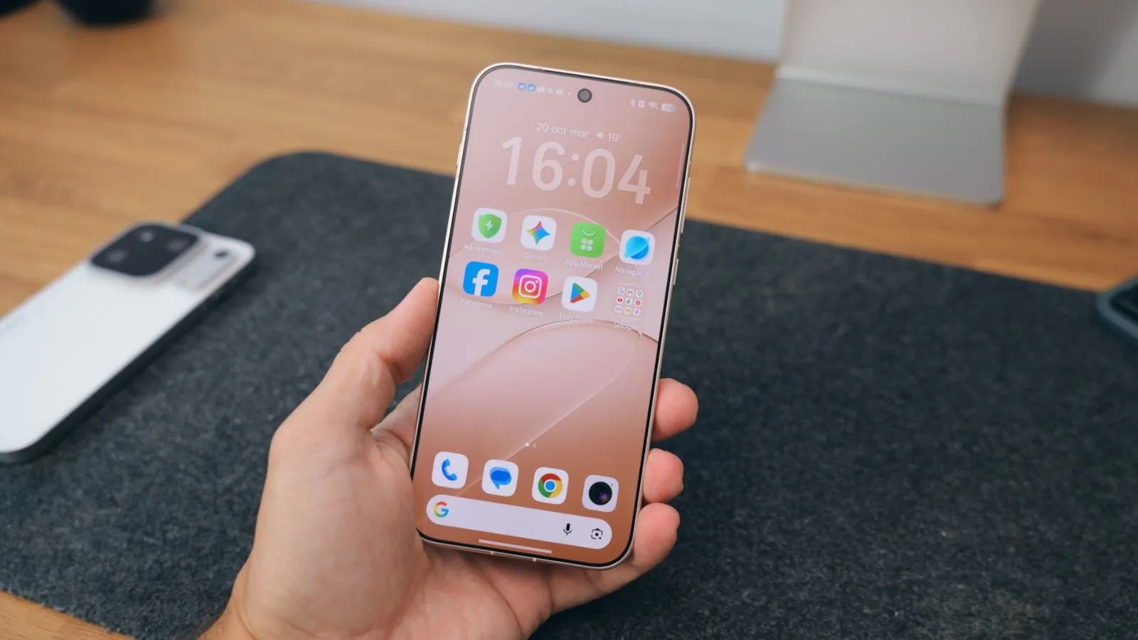 Android 17 a une date pour plus de 50 smartphones : découvrez quand le vôtre recevra la mise à jour 3 Premier plan sur l'écran d'accueil d'un OPPO Find X10 dans la main d'un utilisateur au-dessus d'un bureau.