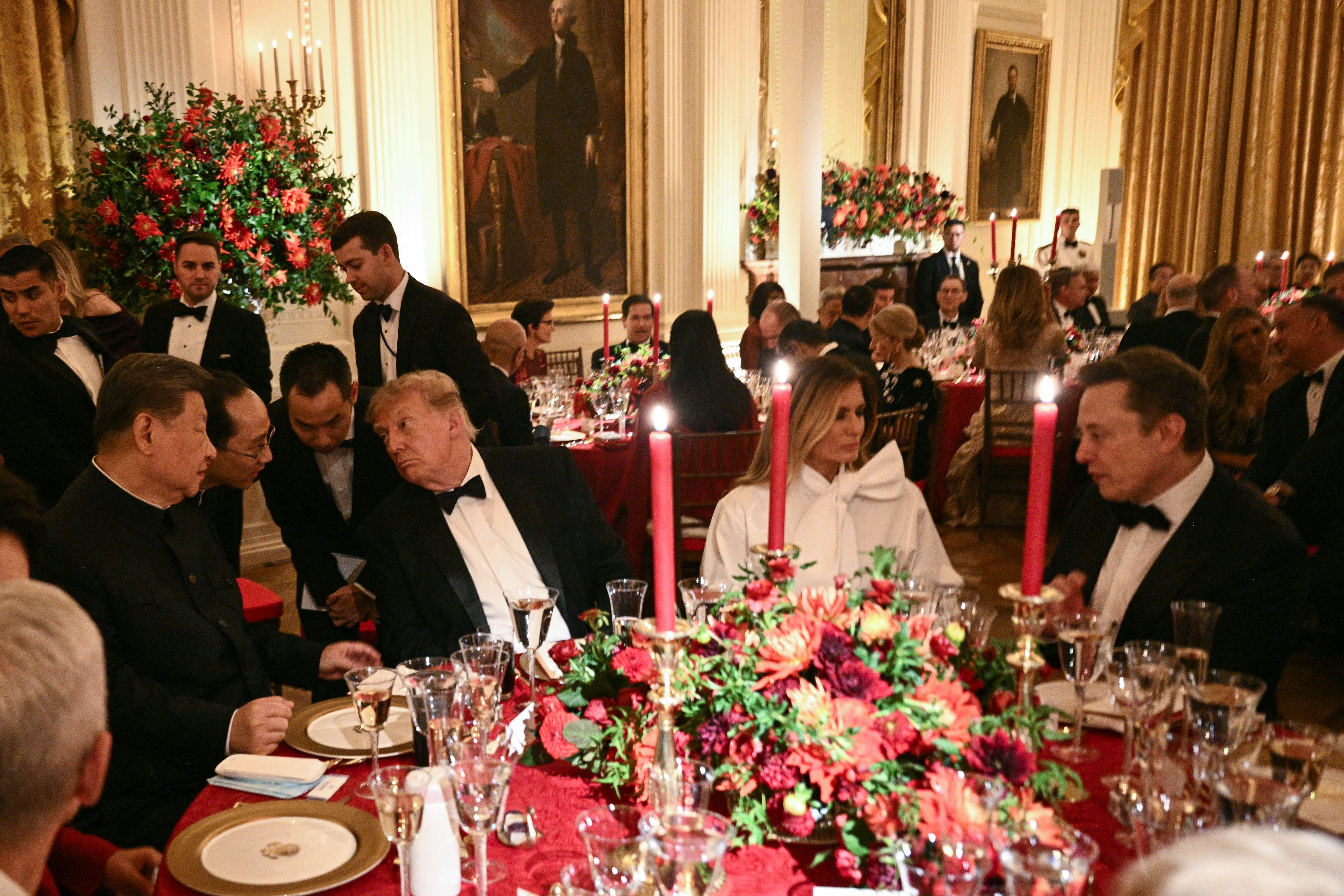 La méga-fusion SpaceX-Tesla pourrait contourner le problème chinois de Musk 2 Le président chinois Xi Jinping (à gauche) et le président américain Donald Trump parlent avec l'aide d'interprètes. La Première dame Melania Trump écoute le PDG de Tesla Elon Musk lors d'un dîner d'État dans la salle Est de la Maison Blanche à Washington, DC, le 24 septembre 2026.